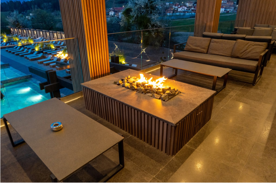 Релакс зона с камина и изглед към външния басейн в Pulse Therme Banya.